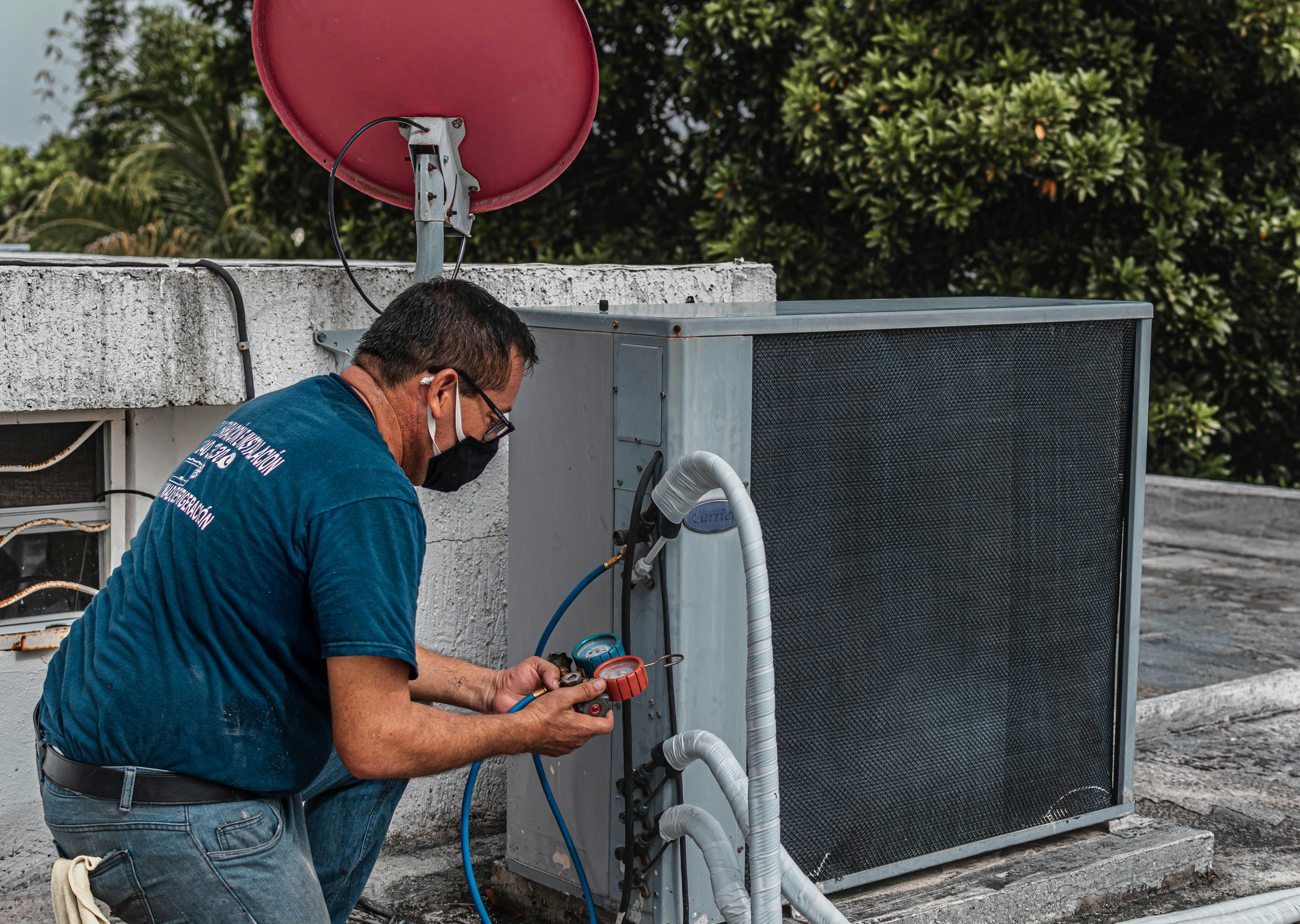 Technician servicing an outdoor air conditioning unit